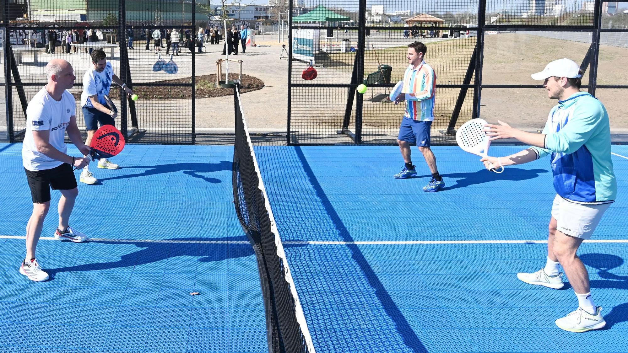 Vier Menschen spielen Tennis.