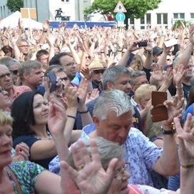 Frauen, Männer und Kinder drängen sich vor einer Bühne und klatschen im Takt zur Musik.