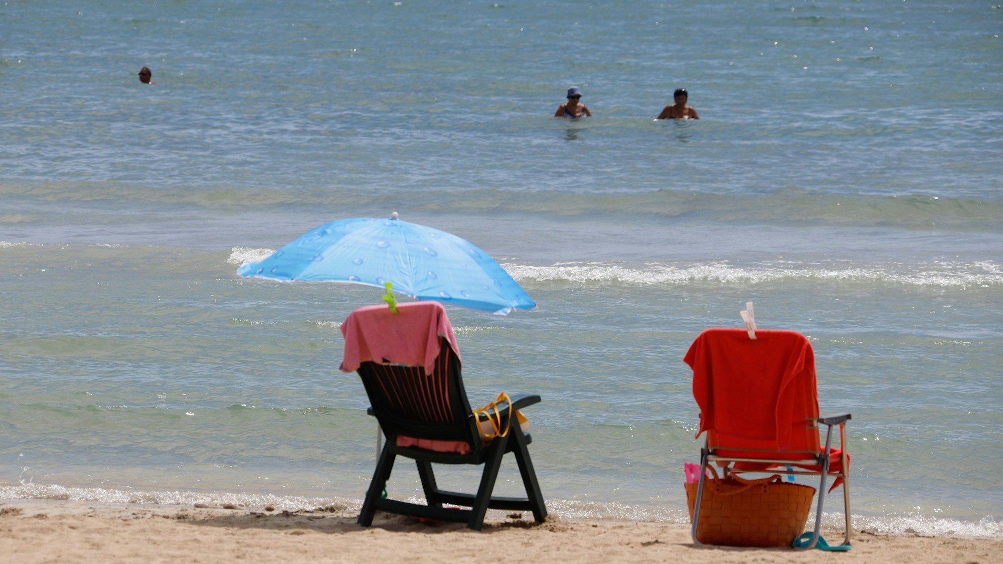 Zwei Sonnenstühle stehen am Strand vor der Küste.
