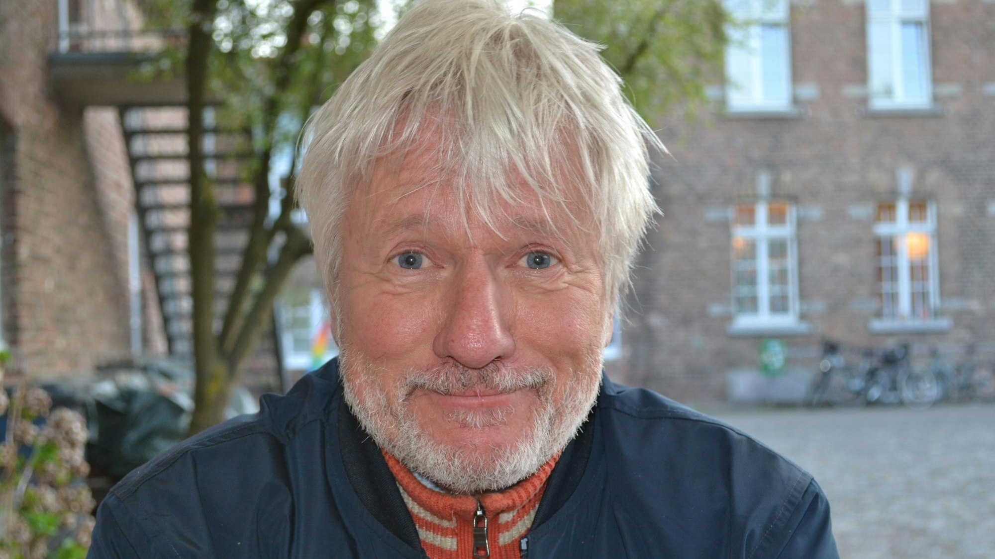 Der Kabarettist Jürgen Becker schmunzelt.