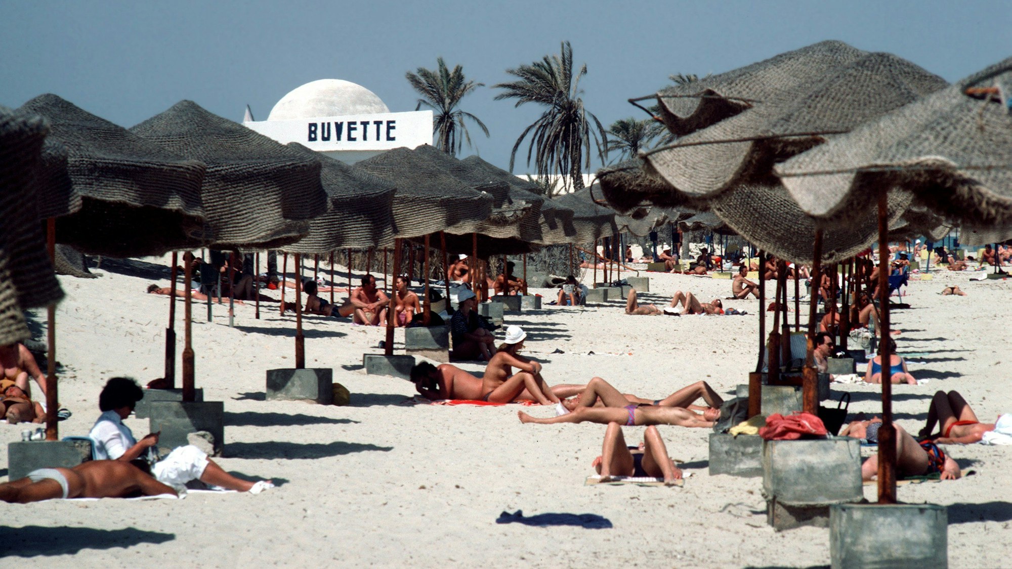Viele Menschen sonnen sich am Strand vor der Hotelanlage Dar Djerba in Tunesien.