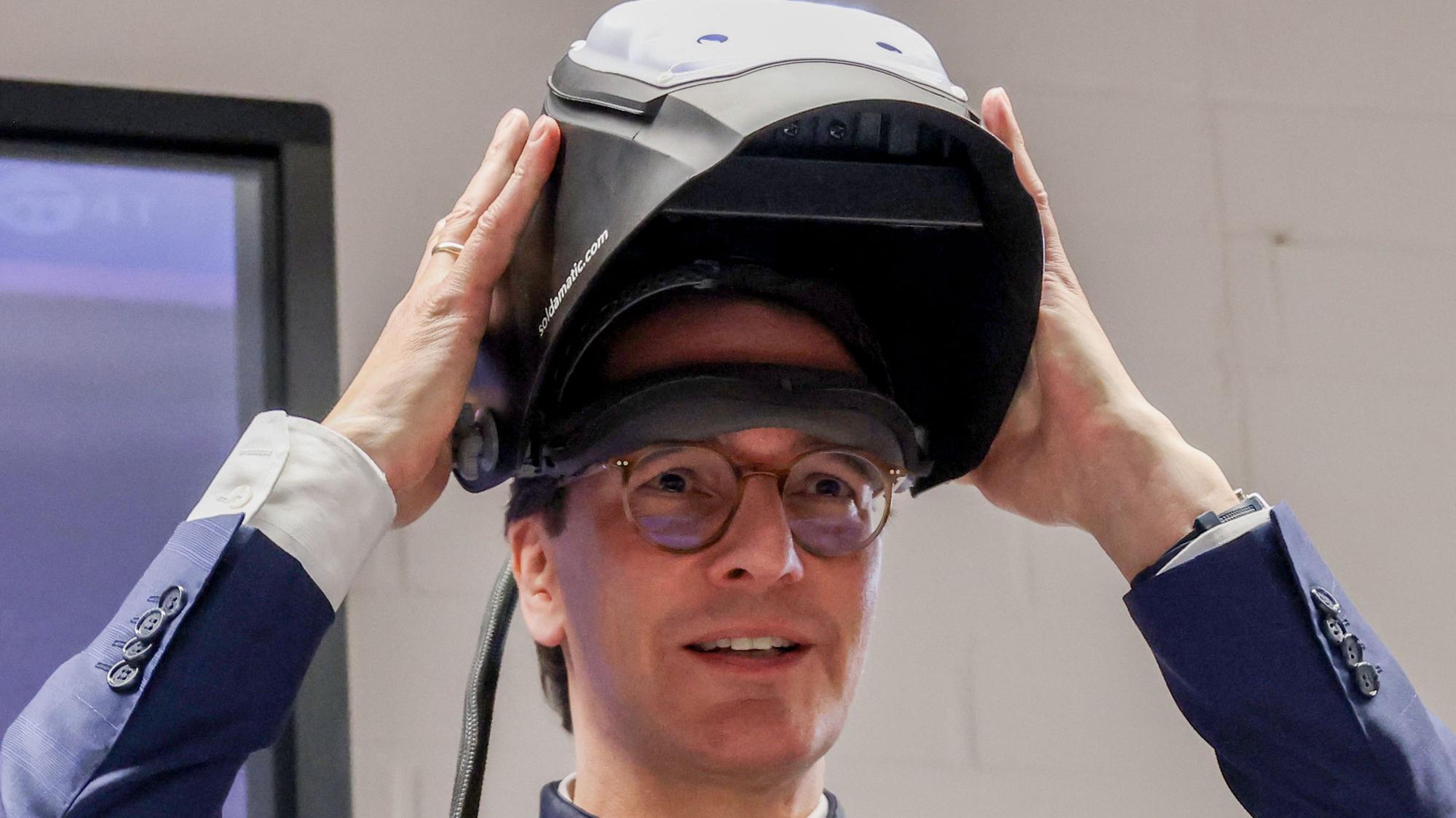 NRW Ministerpräsident Hendrik Wüst tourt durch das Rheinland und besucht den Ausbildungscampus der Handwerkskammer in Köln - Wüst mit Schweißmaske.