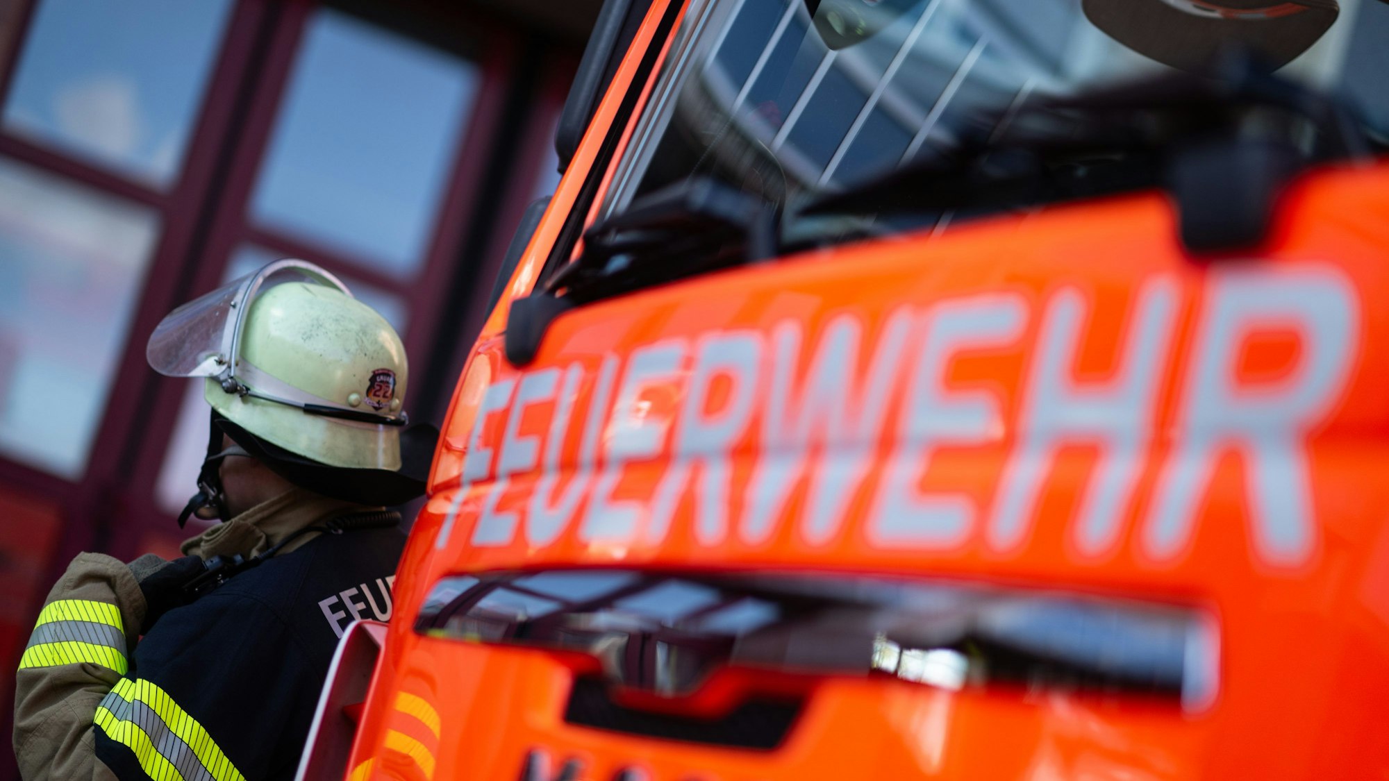 ILLUSTRATION - 08.11.2023, Baden-Württemberg, Stuttgart: Eine Einsatzkraft der Feuerwehr steht neben einem Einsatzfahrzeug der Feuerwehr. (zu dpa: «Backautomat fängt Feuer in Supermarkt») Foto: Marijan Murat/dpa +++ dpa-Bildfunk +++