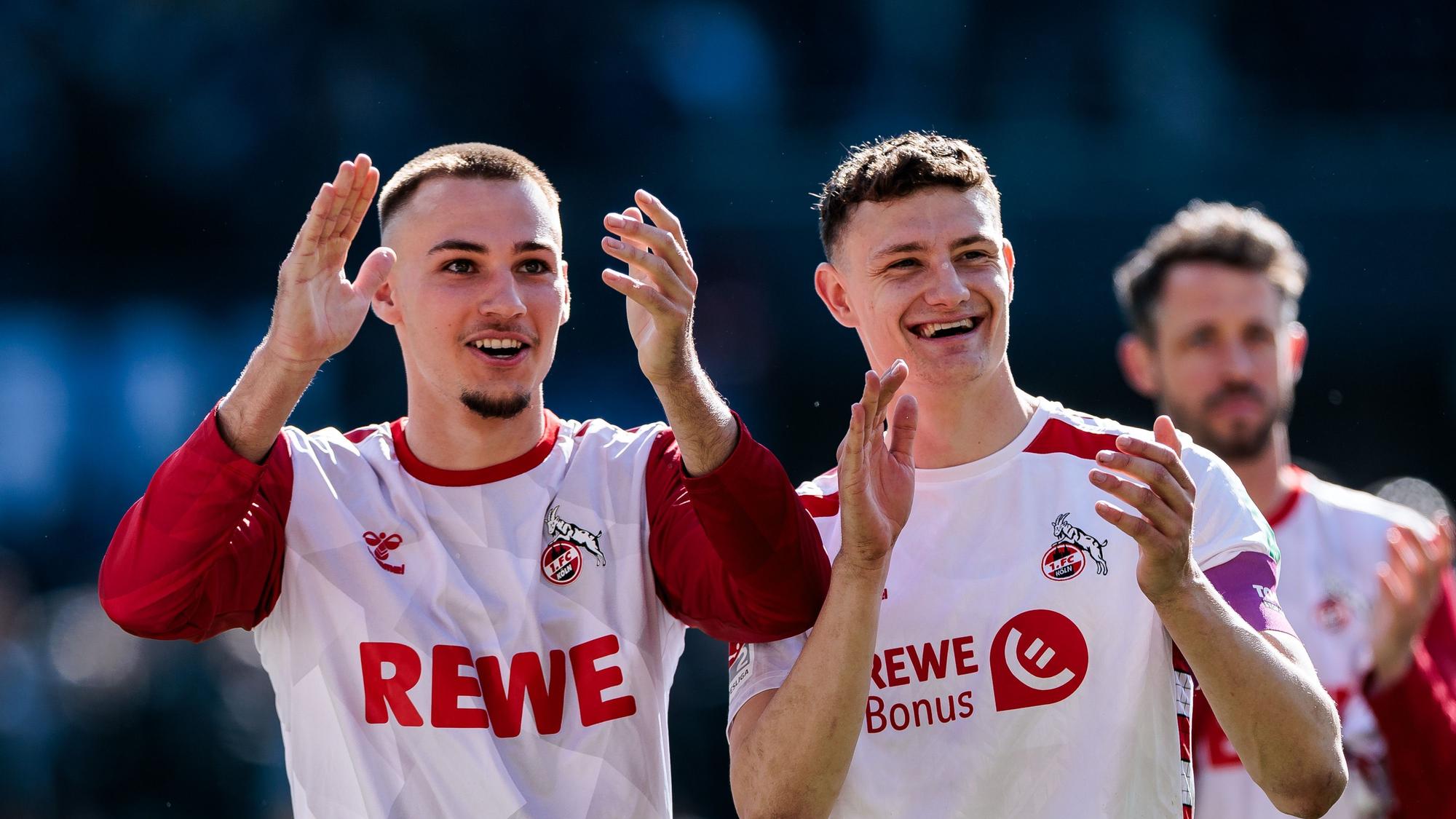Tim Lemperle und Eric Martel applaudieren lachend Richtung Fans.
