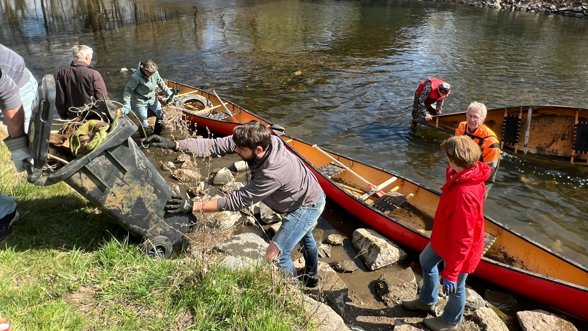 Kanufahrer laden am Wupperufer Müll aus.