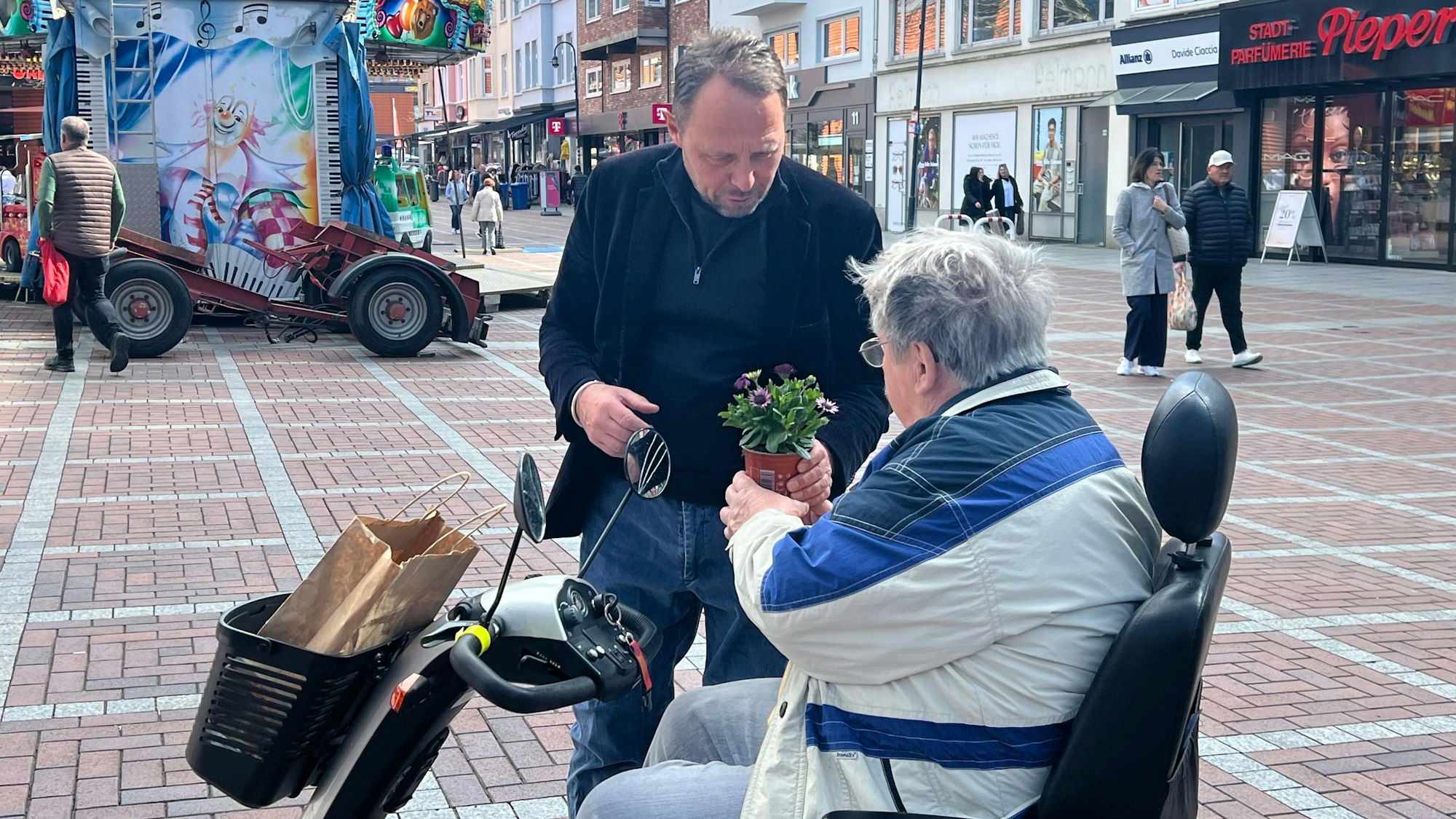 Rollstuhlfahrer Fritz Kus bekommt Blumen vom OB.