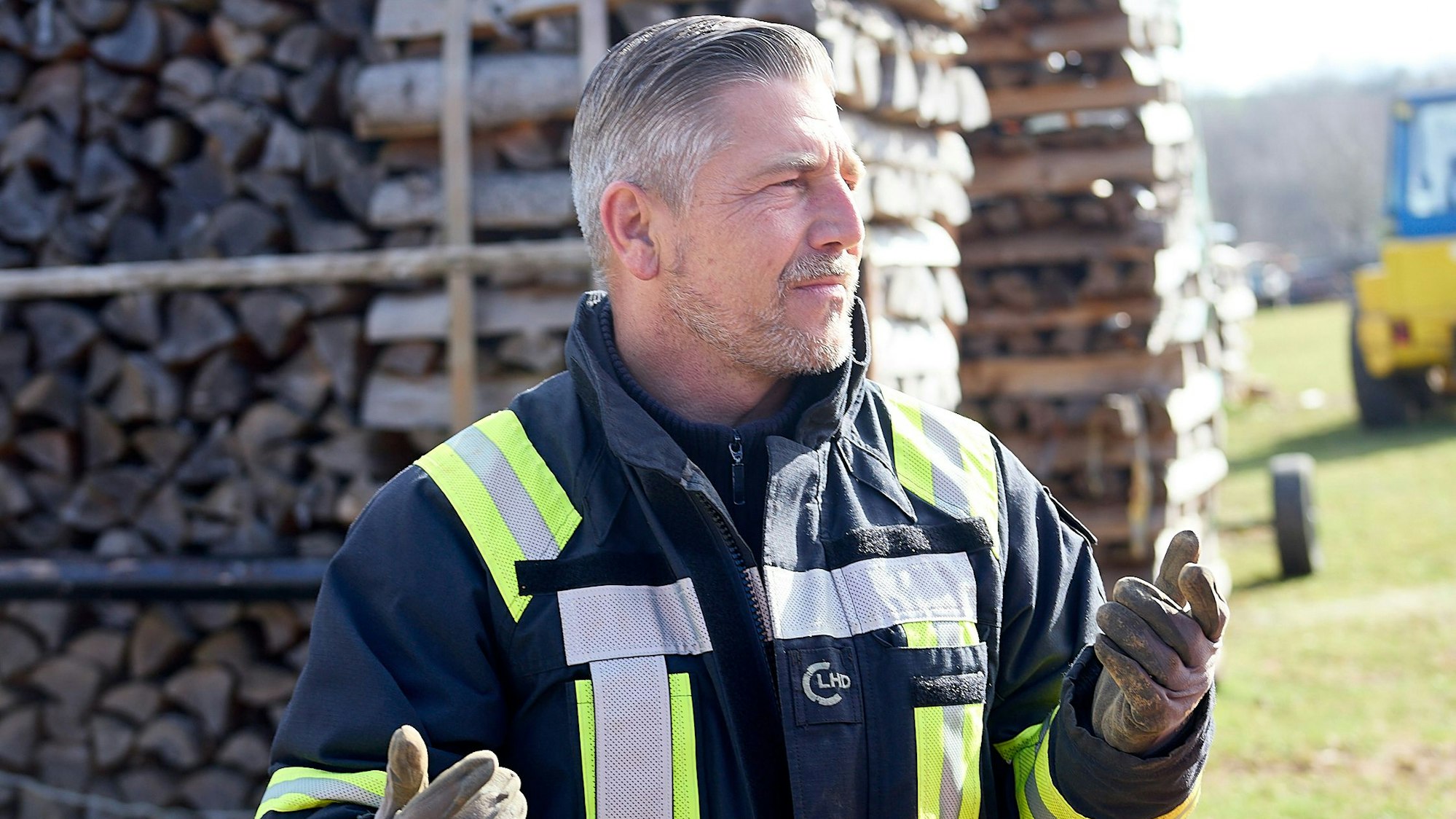 Marcel Biewald trägt eine blaue Schutzjacke mit Reflektorstreifen. Er ist Sprengmeister und sprengt in Schleiden-Morsbach eine Granate aus dem Zweiten Weltkrieg.