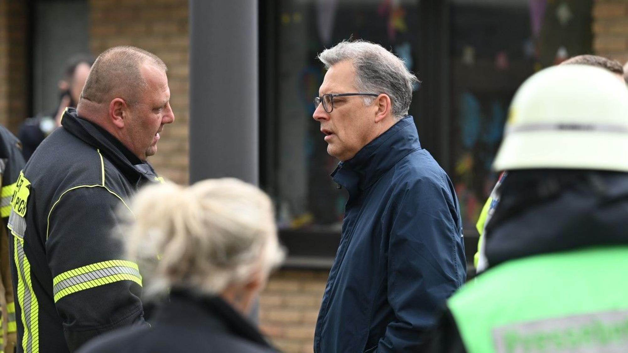 Zülpichs Bürgermeister Ulf Hürtgen spricht mit einem Feuerwehrmann.