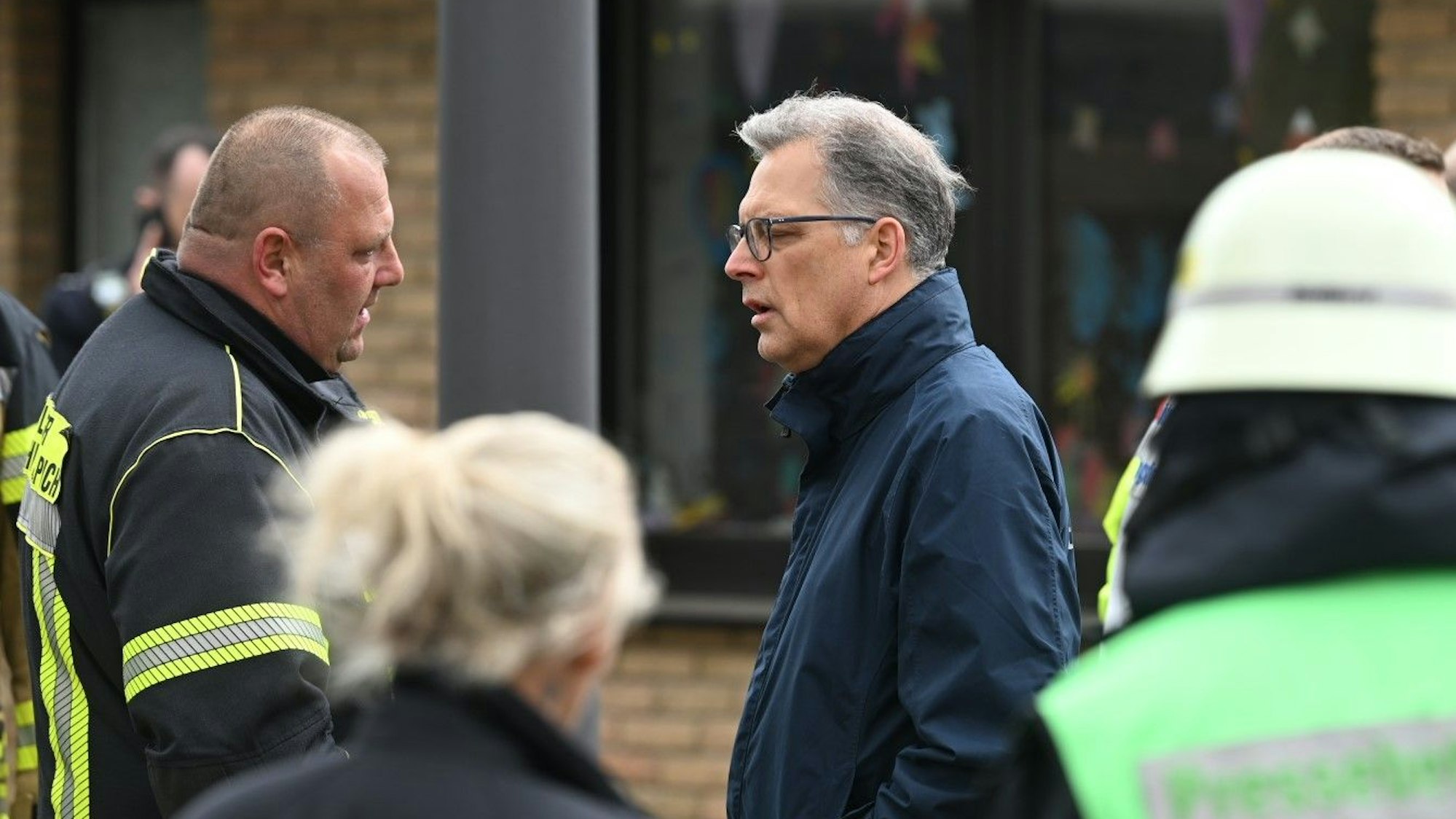 Zülpichs Bürgermeister Ulf Hürtgen spricht mit einem Feuerwehrmann.