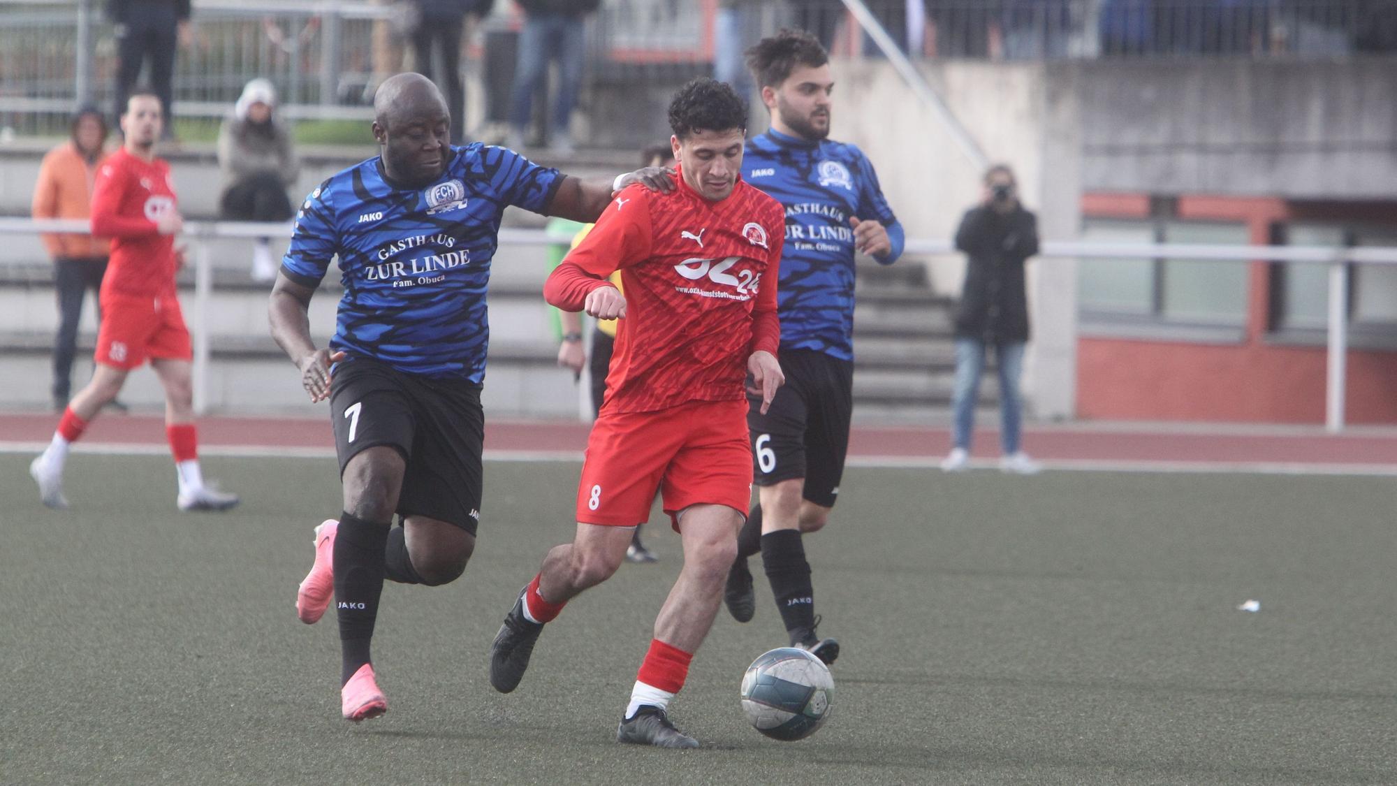 Gagik Arutiunian vom 1. FC Niederkassel (rechts) wird vom Rheidter Beckly Gwe Fotem attackiert.
