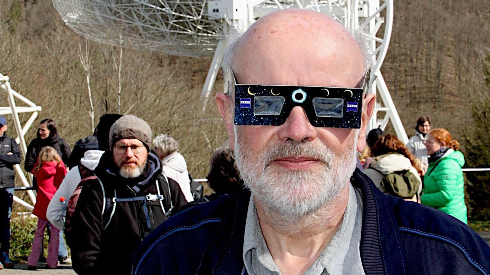 Dr. Norbert Junkes trägt eine Schutzbrille, um die partielle Sonnenfinsternis zu betrachten.