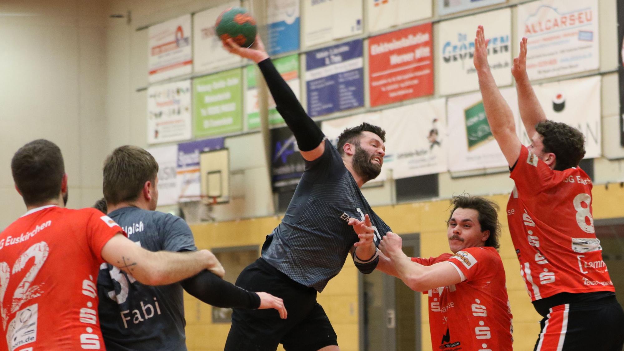 Daniel Schüller nimmt all seine Kraft zum Wurf zusammen. Sein Spielertrainer blockt den Weg frei. Ein Gegner zerrt an Schüllers Trikot, ein anderer reißt die Arme ur Abwehr hoch.