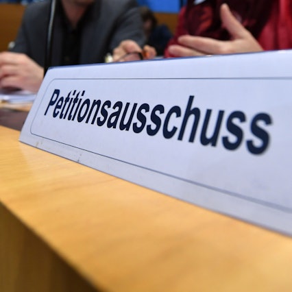 Ein Schild mit der Aufschrift „Petitionsausschuss“ steht auf einem Tisch. Im vergangenen Jahr wurden beim NRW-Landtag etwa 4.600 Petitionen eingereicht.