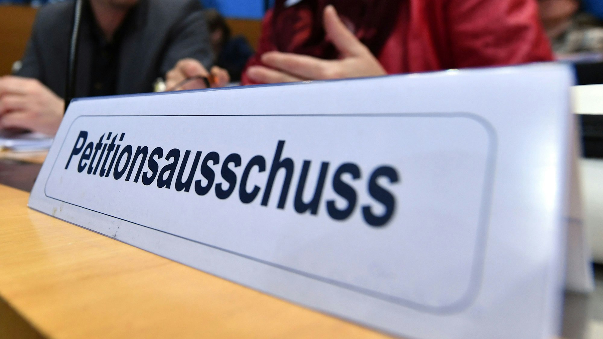 Ein Schild mit der Aufschrift „Petitionsausschuss“ steht auf einem Tisch. Im vergangenen Jahr wurden beim NRW-Landtag etwa 4.600 Petitionen eingereicht.