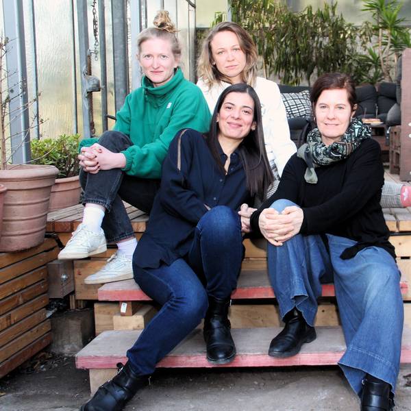 Vier Frauen sitzen auf einer Holz-Terasse.