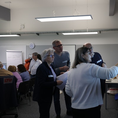 Menschen arbeiten in einem Raum zusammen.