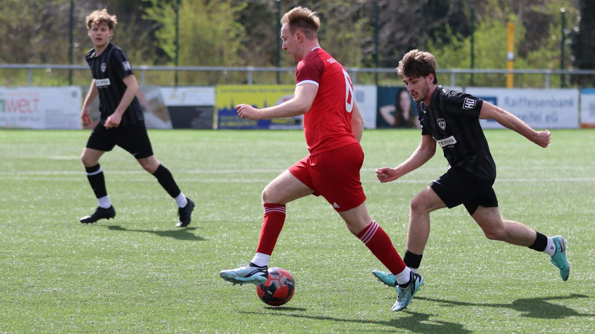 Das Bild zeigt den Mechernicher Fußballer, der den Ball führt. Ein Spieler der JSG Erft Euskirchen ist in Lauerstellung.