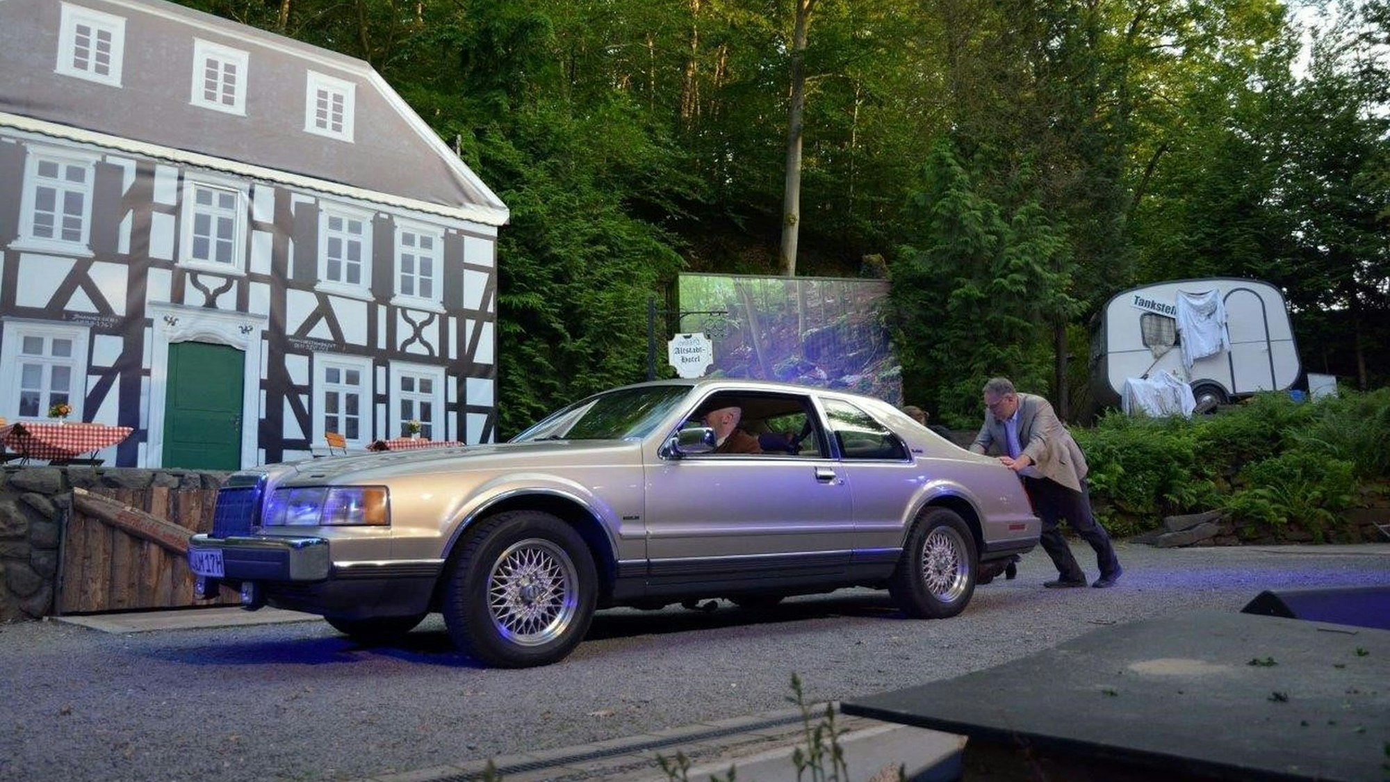 Ein Mann schiebt einen Mercedes.