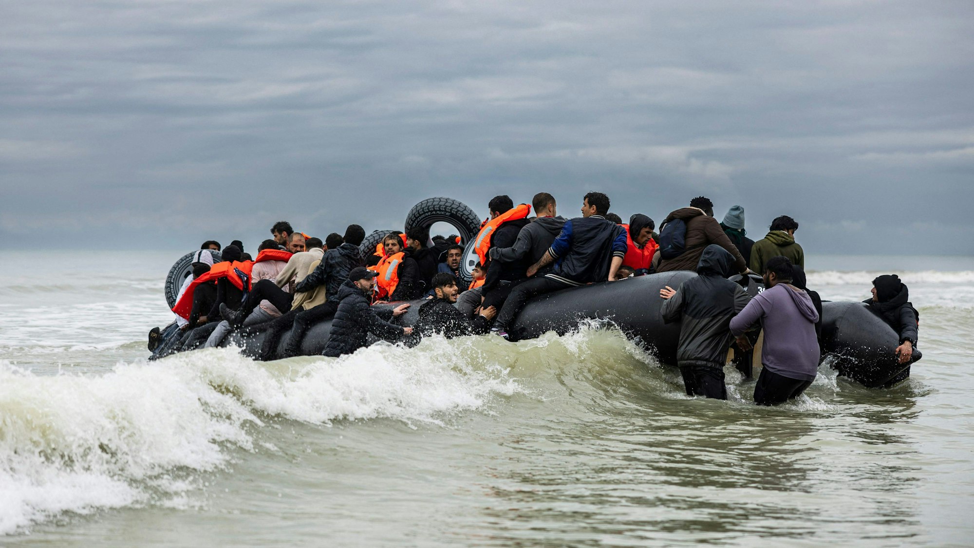 Frankreich, Saint-Étienne-Au-Mont: Migranten besteigen das Schlauchboot eines Schmugglers und versuchen, den Ärmelkanal zu überqueren.