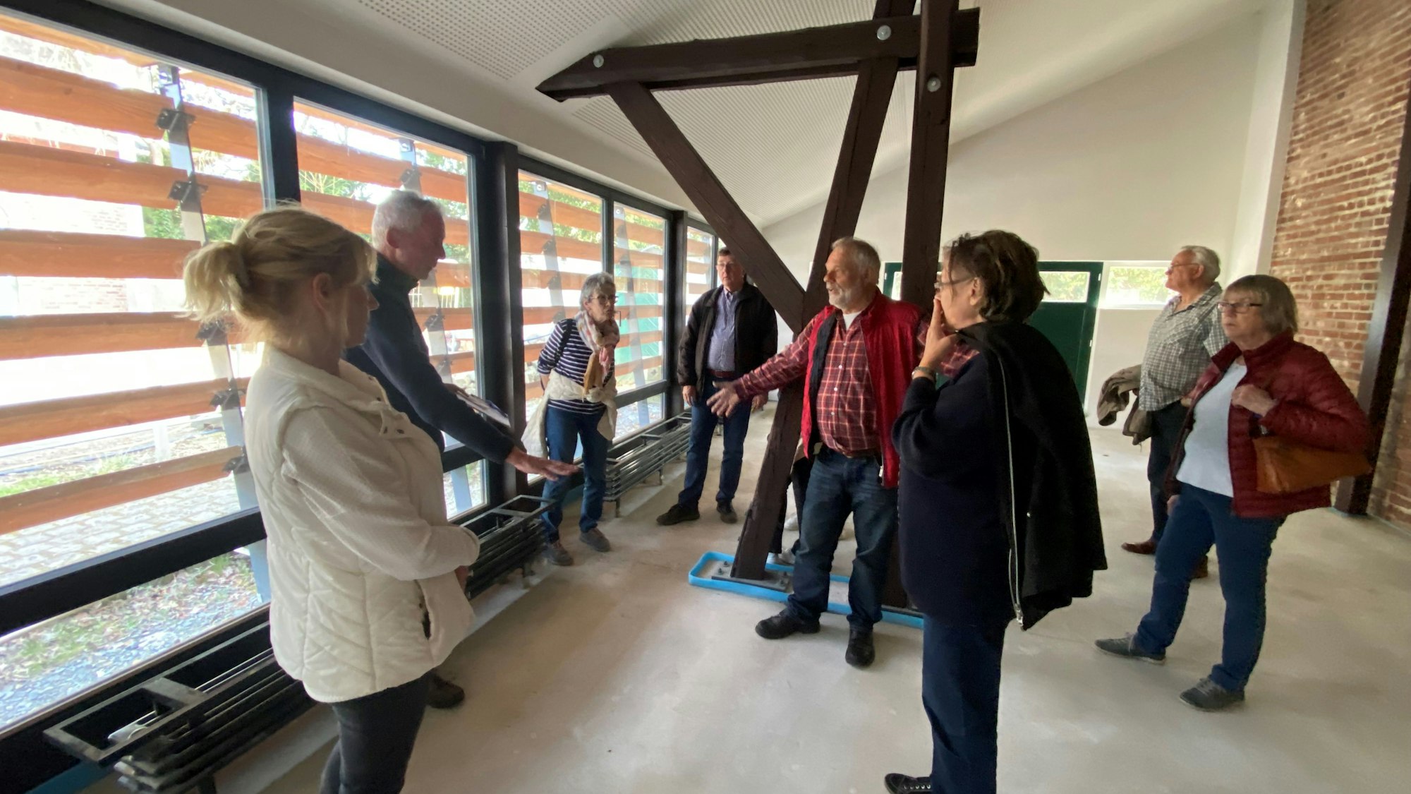 Personen stehen in einem luftigen Raum der neu erweiterten Waldschule auf Gut Leidenhausen