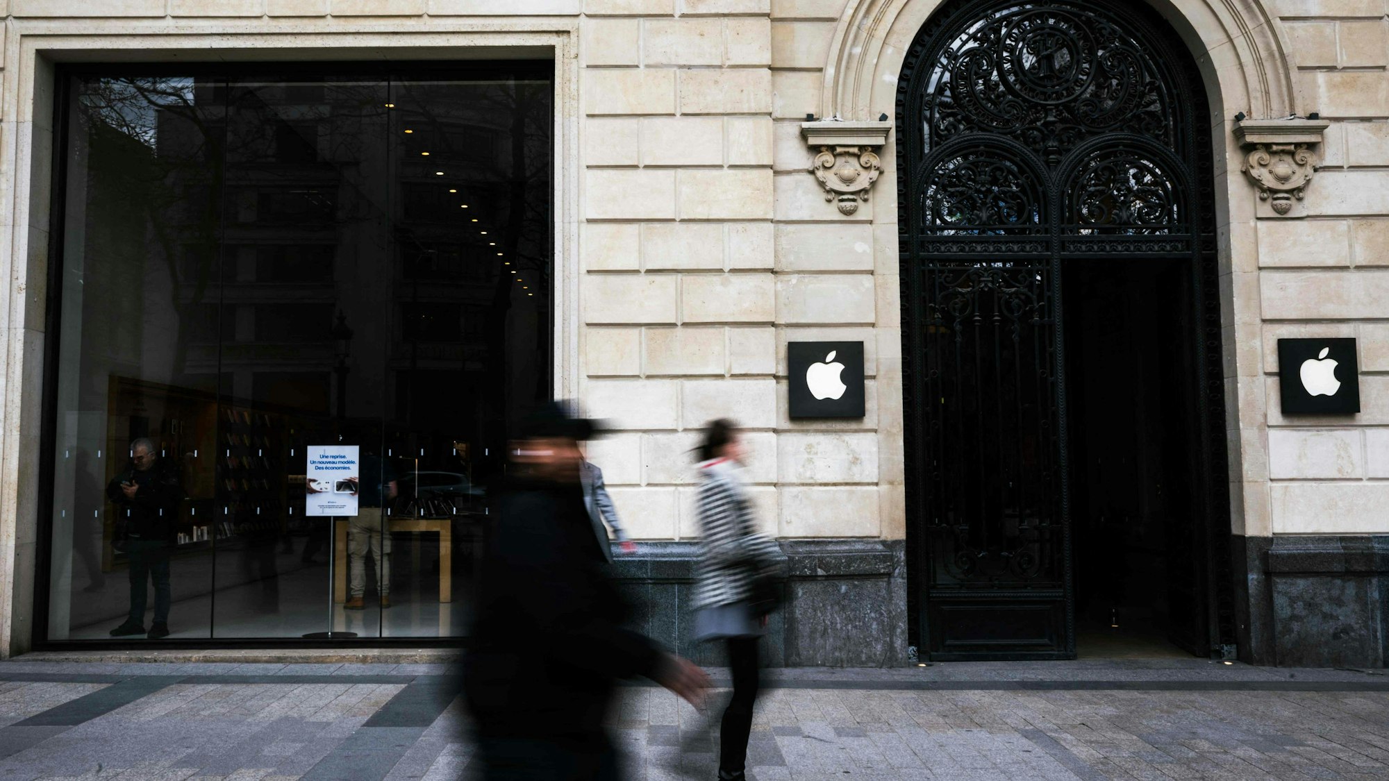 Fußgänger laufen an einem Apple Store auf der Champs-Elysees vorbei.
