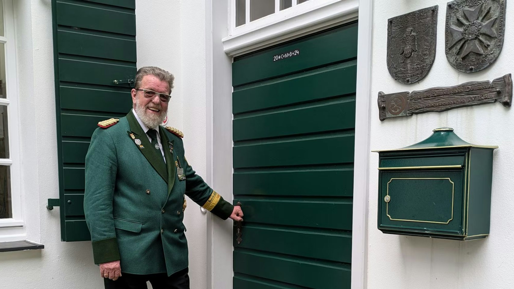 Ein Schützenbruder steht an einem Hauseingang