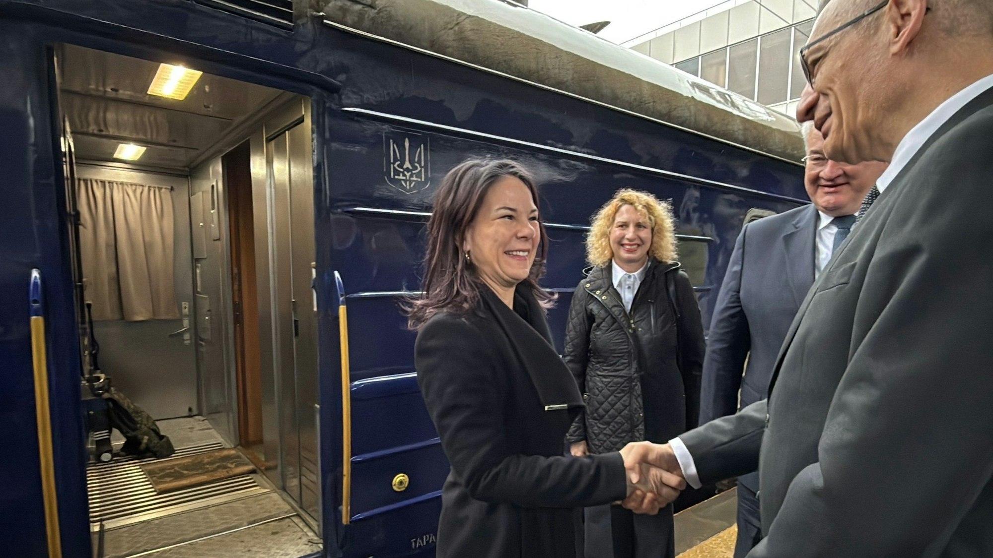 Annalena Baerbock wird bei ihrer Ankunft am Bahnsteig in Kiew von Andrij Sybiha (hinten), Außenminister der Ukraine, und dem deutschen Botschafter Martin Jäger (r) begrüßt. (Videostandbild)