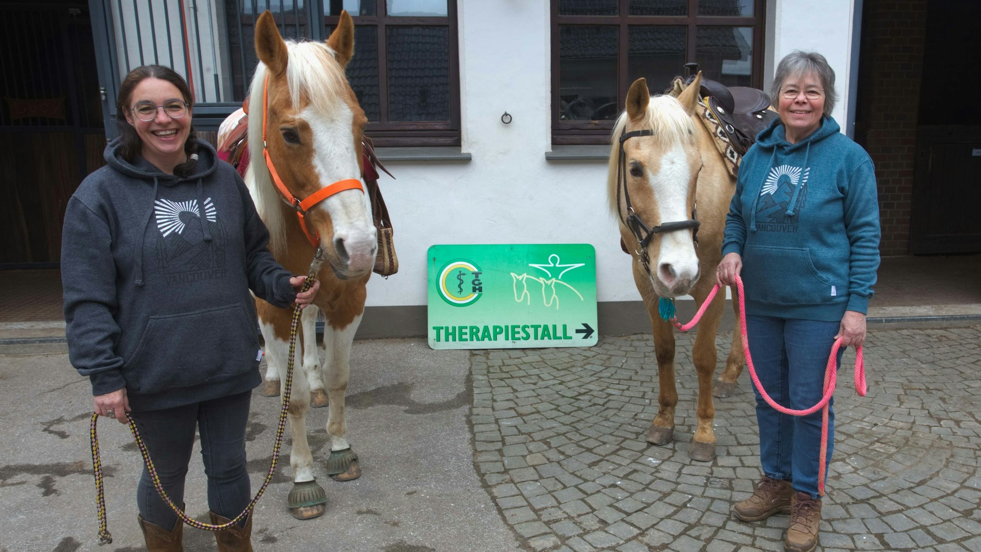 Zwei Frauen mit Pferden.