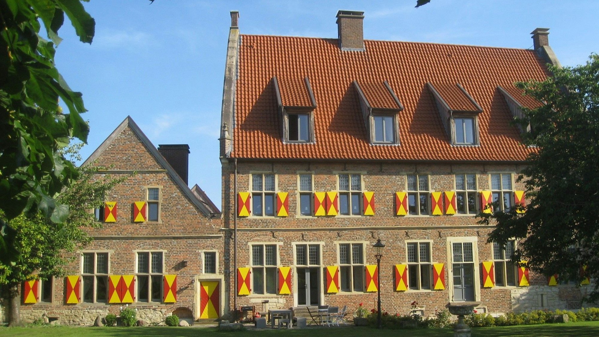 Der Münsterhof in Horstmar hat ein rotes Dach und rot-gelbe Fensterläden.