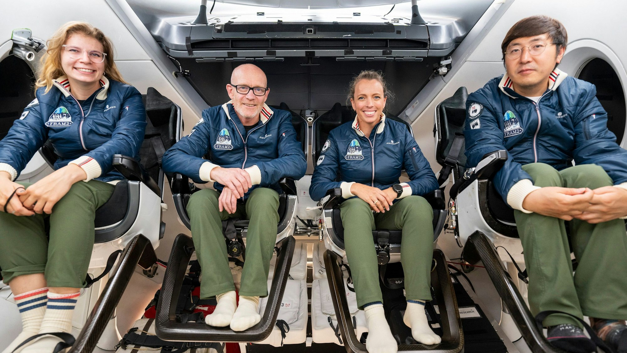 Die Raumfahrer Rabea Rogge (l-r), Eric Philips, Jannicke Mikkelsen und Chun Wang üben in einer „Dragon“-Kapsel von SpaceX.