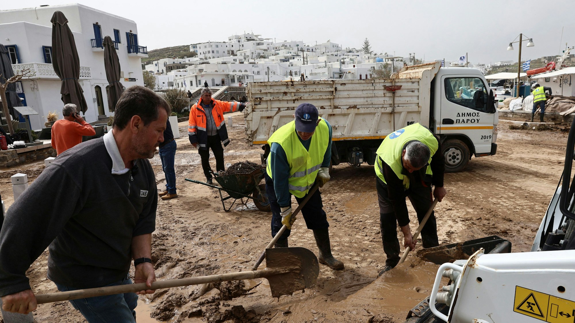 Auf der Ägäisinsel Paros schaufeln Helfer Schlamm von den Straßen.