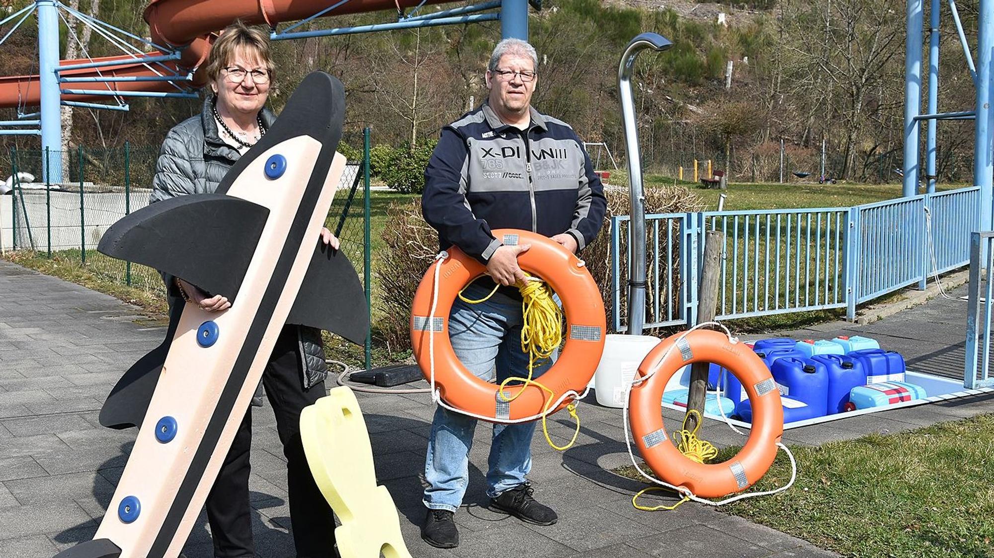 Ein Mann und eine Frau prüfen Spielgeräte fürs Wasser.