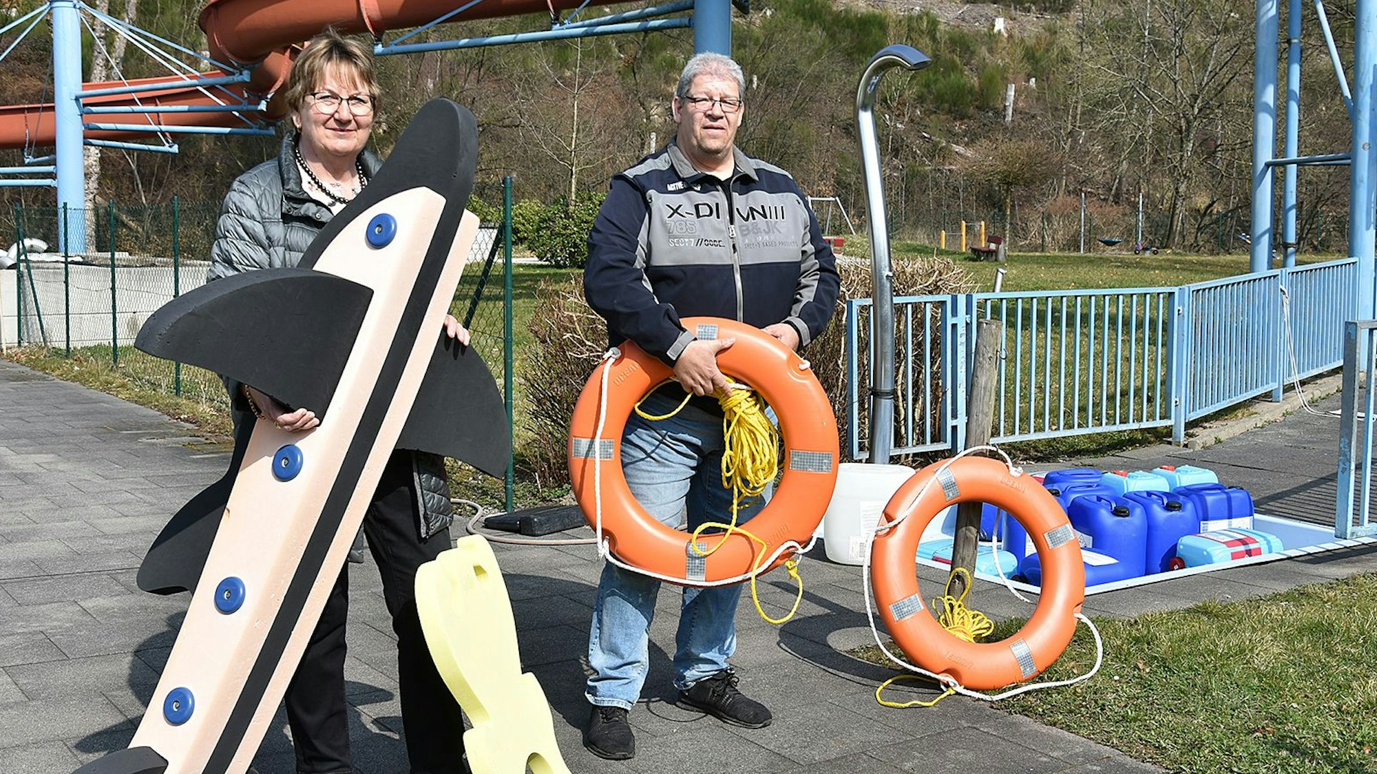 Ein Mann und eine Frau prüfen Spielgeräte fürs Wasser.