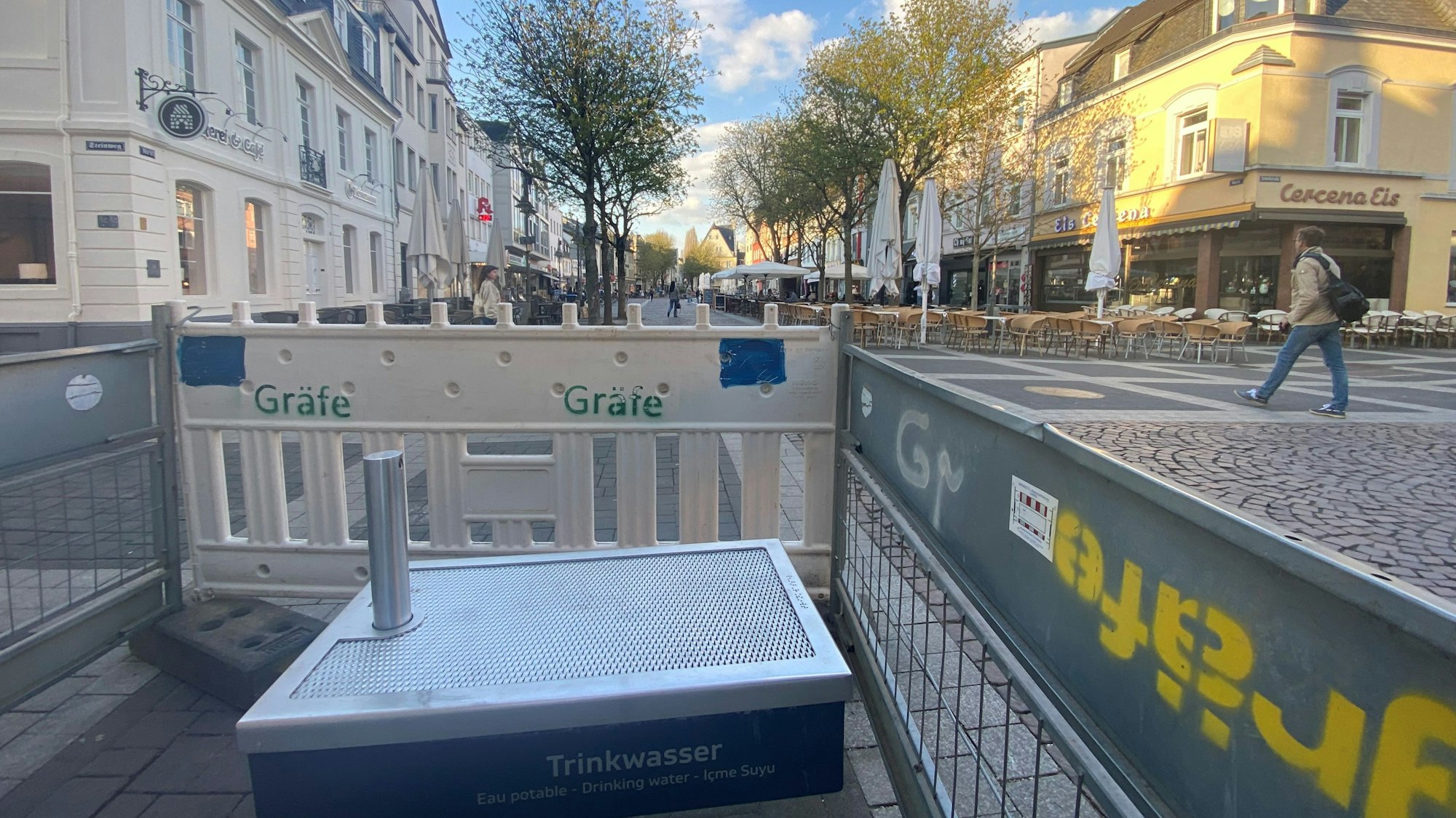 Zu sehen ist einer der Trinkwasserbrunnen, der von einem Bauzaun abgeschirmt wird.