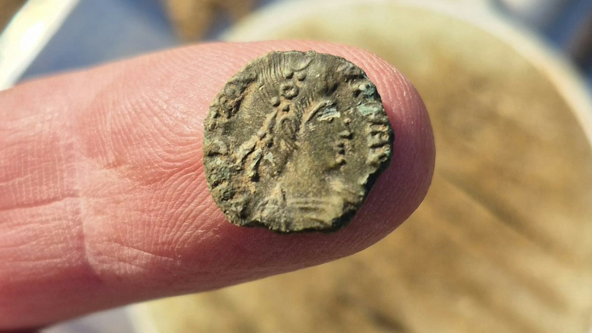 Der „German Treasure Hunter“ zeigt die römische Constantin-Münze auf seinem Finger.
