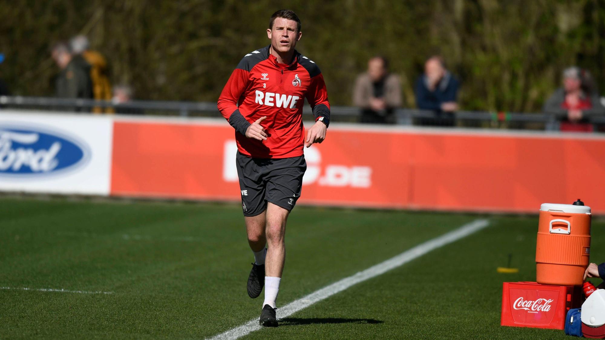 Ein Fußballspieler joggt über einen Platz.