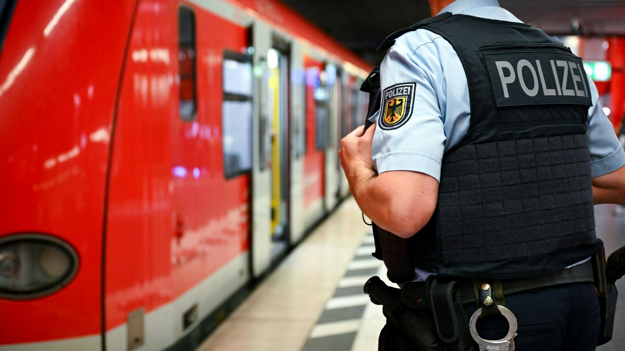 Ein Bundespolizist steht an einer S-Bahn. (Symbolbild)