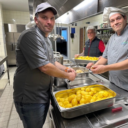 In der Küche: Koch Lars Nossal, Büdchen-Betreiber Mario Schmitz und Koch Tobias Peter (v.l.) beim Schälen von Kartoffeln für den Kartoffelsalat.