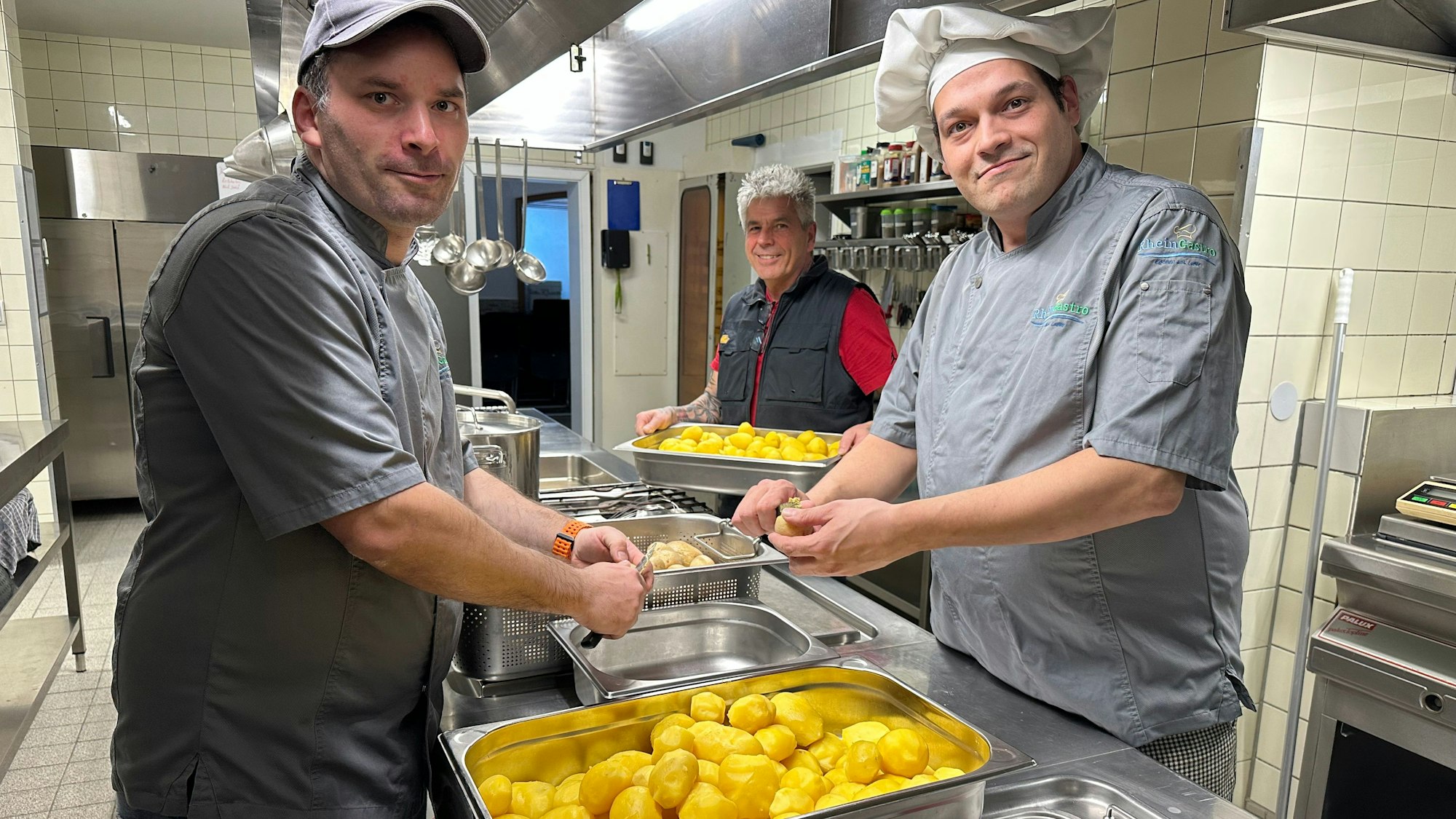 In der Küche: Koch Lars Nossal, Büdchen-Betreiber Mario Schmitz und Koch Tobias Peter (v.l.) beim Schälen von Kartoffeln für den Kartoffelsalat.
