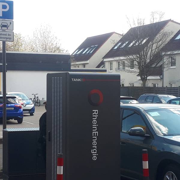 Autos stehen neben einer Elektro-Ladesäule vor einem Netto-Supermarkt.