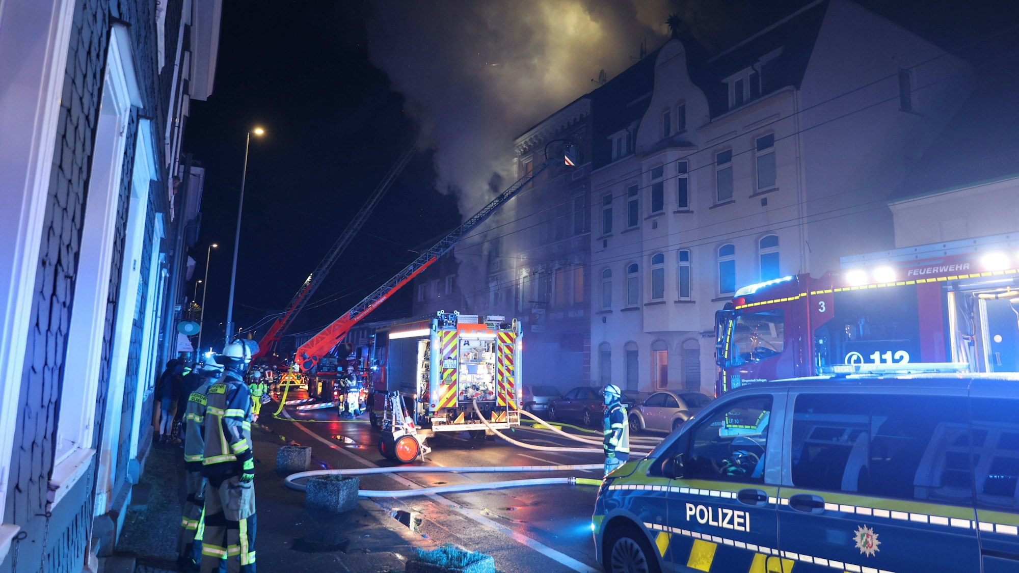 Nächtliche Szene um Löscharbeiten und Polizeieinsatz am Tatort.