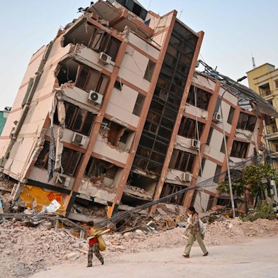 Kinder gehen am 2. April 2025, fünf Tage nach einem schweren Erdbeben in Zentral-Myanmar, an einem eingestürzten Gebäude in Mandalay vorbei. Auch Tage nach einem Erdbeben der Stärke 7,7, bei dem mehr als 2.000 Menschen ums Leben kamen, schlafen viele Menschen in Myanmar noch immer im Freien, da sie entweder nicht in ihre zerstörten Häuser zurückkehren können oder Angst vor weiteren Nachbeben haben. Übersetzt mit DeepL.com (kostenlose Version)