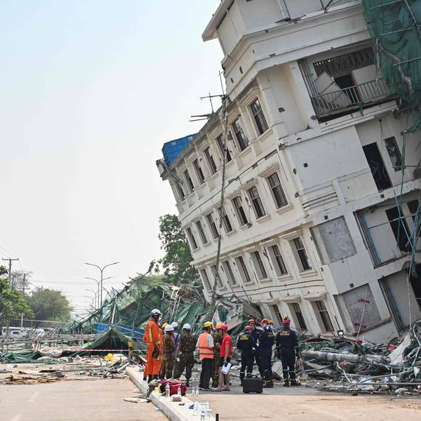 Rettungsteams an einem teilweise eingestürzten Gebäude in Mandalay.