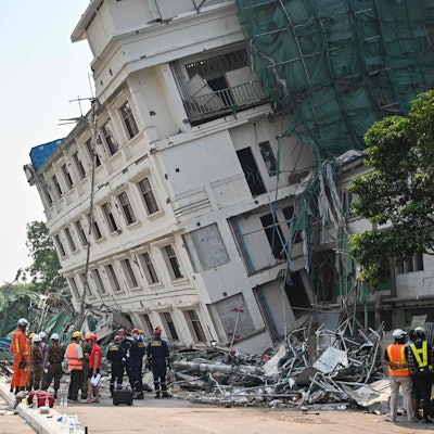 Rettungsteams an einem teilweise eingestürzten Gebäude in Mandalay.
