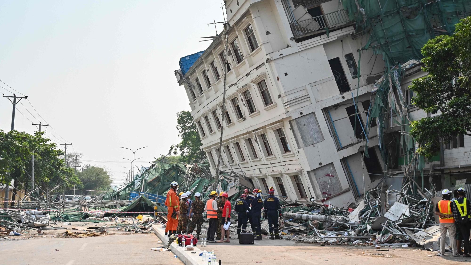 Rettungsteams an einem teilweise eingestürzten Gebäude in Mandalay.