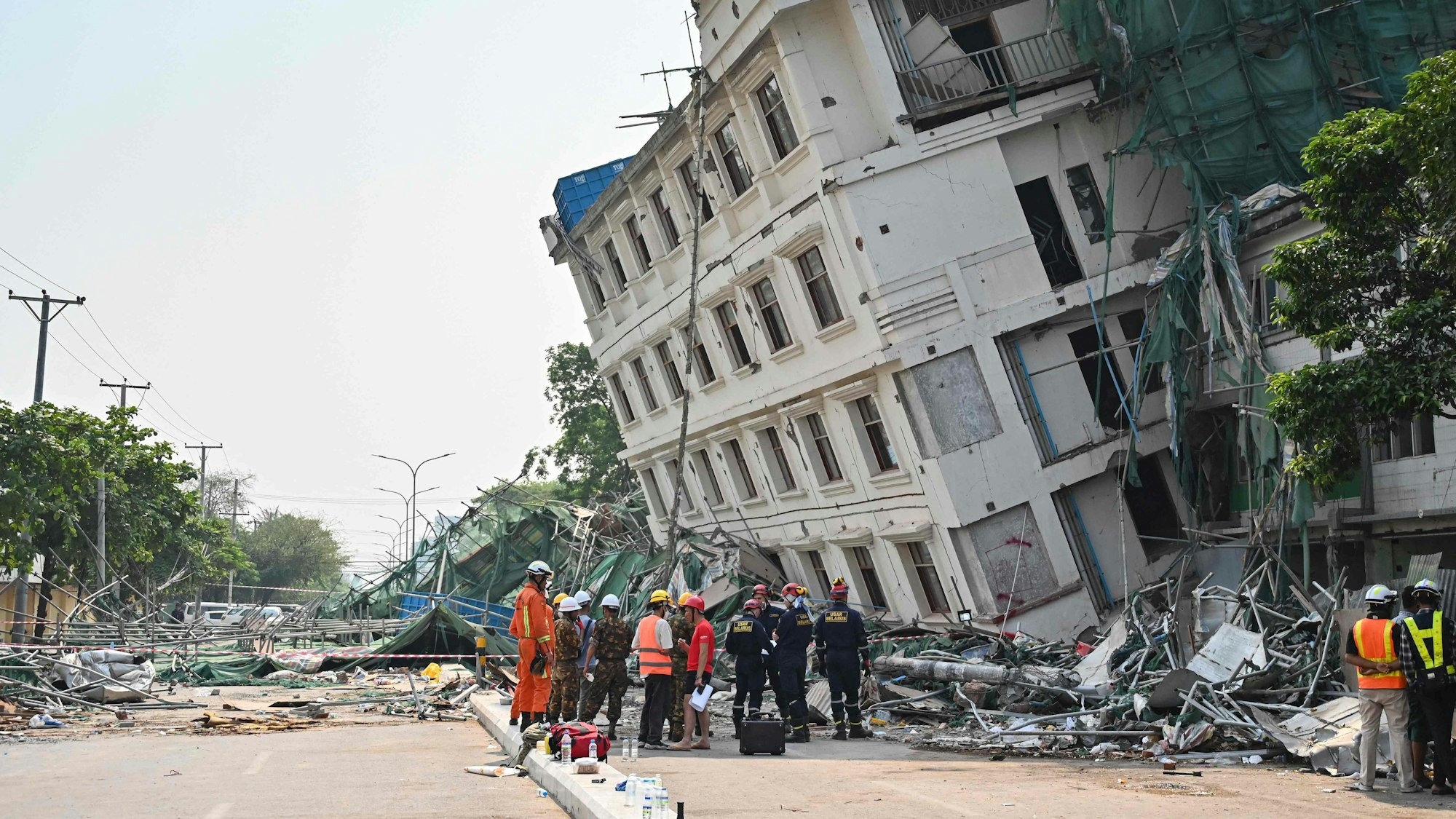 Rettungsteams an einem teilweise eingestürzten Gebäude in Mandalay.