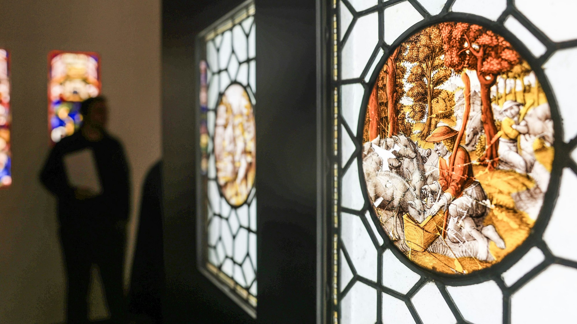 dpatopbilder - 02.04.2025, Nordrhein-Westfalen, Köln: Die Glasmalerei «Der verlorene Sohn hütet die Schweine» hängt in der Ausstellung «Licht in dunklen Zeiten - Mittelalterliche Glasmalerei aus dem Khanenko Museum in Kiew». Glasmalereien aus Kiew sollen in Köln mit Hilfe der Dombauhütte restauriert werden. Das Khanenko Museum wurde bereits im ersten Jahr des russischen Angriffskriegs durch einen Raketeneinschlag in Mitleidenschaft gezogen. Foto: Oliver Berg/dpa - ACHTUNG: Nur zur redaktionellen Verwendung im Zusammenhang mit der aktuellen Berichterstattung über die Ausstellung und nur mit vollständiger Nennung des vorstehenden Credits +++ dpa-Bildfunk +++