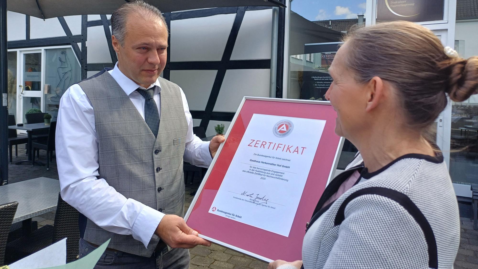 Nicole Jordy (r.) von der Agentur für Arbeit überreicht Geschäftsführer Kresimir Kozina stellvertretend für das ganze Unternehmen das Zertifikat.