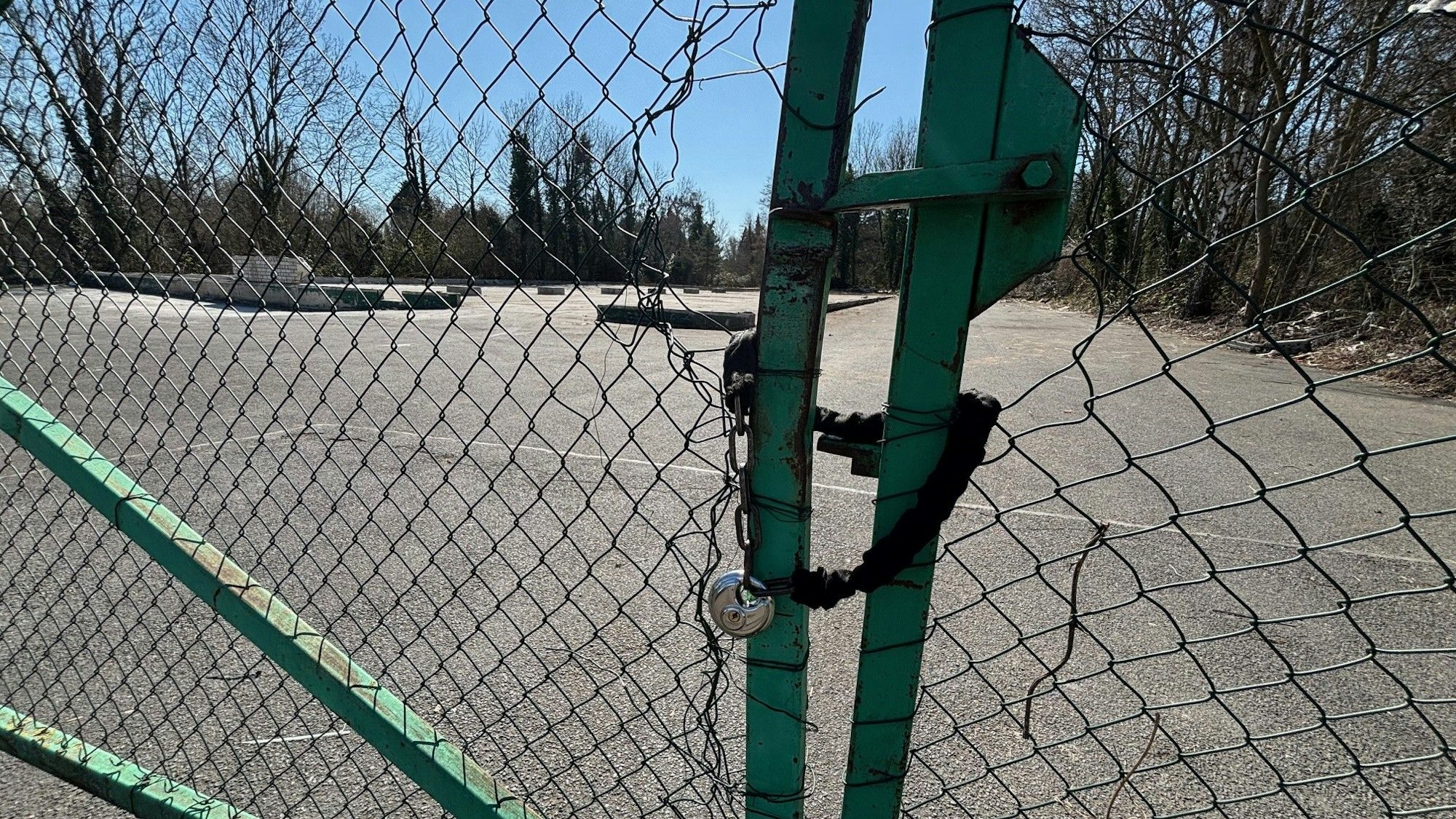 Auf dem Bild ist ein leeres Grundstück durch einen Maschendrahtzaun zu sehen.