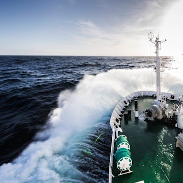 Der Bug eines Schiffes wird auf dem Weg zur Antarktischen Halbinsel durch die Drake-Passage von rauer See umtost.